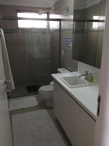 a bathroom with a toilet and a sink and a shower at Extraordinary Seafront Apartment in Recife +20 photos