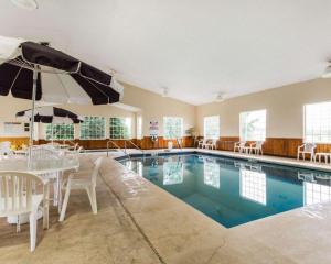 une piscine avec une table, des chaises et un parasol dans l'établissement Quality Inn Edgerton, à Edgerton