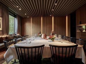 un lungo tavolo in una stanza con sedie e fiori di SO/ Berlin Das Stue a Berlino