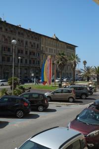 a parking lot with cars parked in front of a large building at 211 Underground in Viareggio +7 photos
