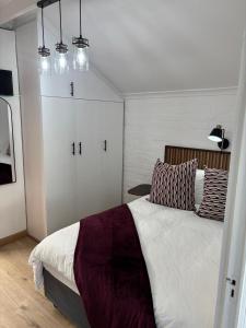 a bedroom with a large bed and white cabinets at Layover on Loerie in Cape Town