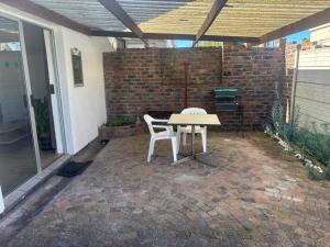 a table and two chairs on a brick patio at Layover on Loerie in Cape Town