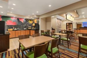 a restaurant with tables and chairs and a kitchen at Amerivu Inn and Suites in Grand Forks