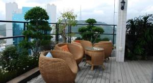 eine Gruppe von Stühlen und Tischen auf einem Balkon in der Unterkunft Silver Art Hotel in Zhuhai