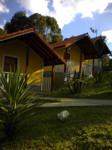 une maison au milieu d'une cour dans l'établissement CHALES Canto dos Pássaros, à Monte Verde