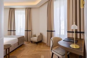 ein Hotelzimmer mit einem Bett, einem Schreibtisch und einem Stuhl in der Unterkunft La Fonda de los Principes in Madrid