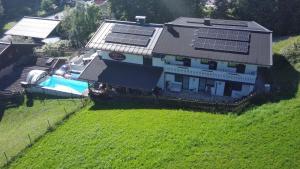 ein Haus mit einem Pool mit Sonnenkollektoren darauf in der Unterkunft Gruber's Gästehaus in Viehhofen