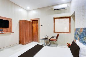 ein Schlafzimmer mit einem Bett, einem Tisch und einem Fernseher in der Unterkunft Hotel O Heritage Inn in Prayagraj