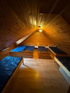 an attic with three beds in a wooden room at Agro Ranczo - Domek na wynajem in Przysietnica