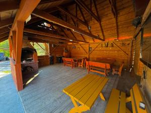 a wooden cabin with benches and a fireplace at Agro Ranczo - Domek na wynajem in Przysietnica