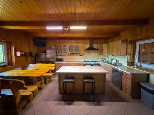 a kitchen with wooden cabinets and a table and chairs at Agro Ranczo - Domek na wynajem in Przysietnica