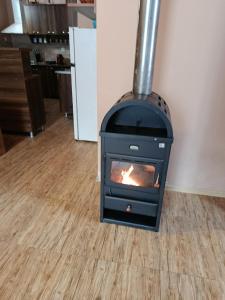 een fornuis in een woonkamer met een houten vloer bij Lela Guest House in Mestia