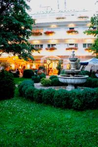 a building with a fountain in front of a building at Seibel's Park Hotel in Munich