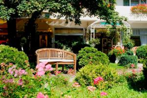 a bench sitting in the middle of a garden with flowers at Seibel's Park Hotel in Munich