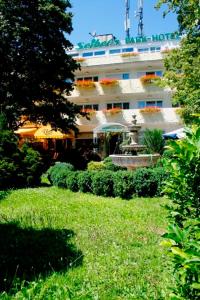 a building with a fountain in the middle of a yard at Seibel's Park Hotel in Munich