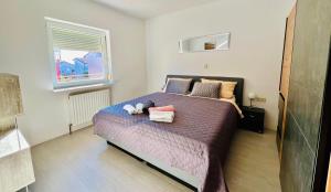 een slaapkamer met een bed met twee knuffels erop bij Apartmani Cassiopeia in Murine
