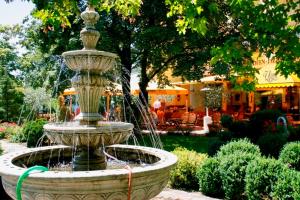 a fountain in the middle of a garden at Seibel's Park Hotel in Munich
