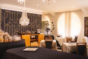 a dining room with two tables and a chandelier at Hotel Globo in Formigine