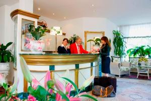 a group of people standing at a bar at Seibel's Park Hotel in Munich