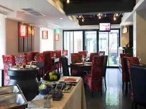 een restaurant met tafels en stoelen en een bar met eten bij Bonito Chinos Hotel in Nakhon Sawan