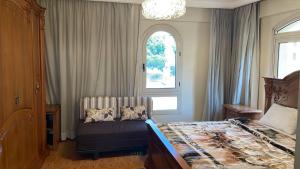 a bedroom with a bed and a window at فيلا كامله للايجار in Kafr Ghaţāţī