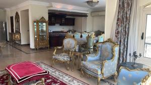 a room with chairs and a table and a kitchen at فيلا كامله للايجار in Kafr Ghaţāţī