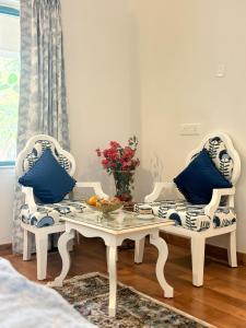 een woonkamer met twee stoelen en een salontafel bij Seclude Hampi 1800 in Jāmb