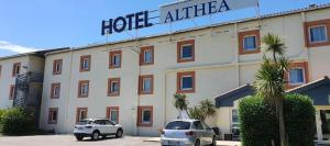 een hotel met twee auto's die er voor geparkeerd staan bij Hôtel Althea - Piscine et Sauna in Béziers