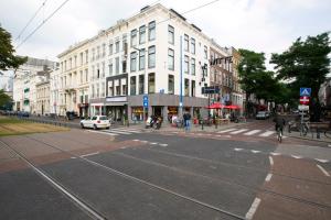 een lege straat met een witte auto op de weg bij De With Studio's in Rotterdam