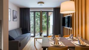 a living room with a table and a couch at BARTAL APARTMENTS - Špindlerův Mlýn in Špindlerův Mlýn