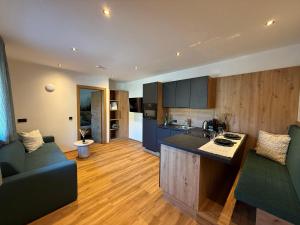 a kitchen and living room with a couch and a table at Apartment Winkl 65 in Maria Alm am Steinernen Meer