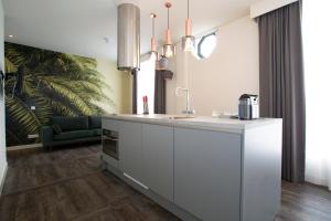 uma cozinha com um balcão branco e um lavatório em De With Studio's em Roterdã