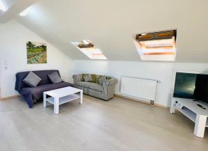 een woonkamer met een bank, een tv en een tafel bij Apartmani Cassiopeia in Murine