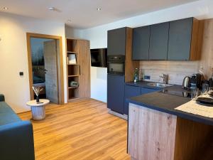 a kitchen with blue cabinets and a counter top at Apartment Winkl 65 in Maria Alm am Steinernen Meer +15 photos