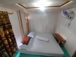 een kleine kamer met een bed en een tafel bij Homestay Komodo Paradise in Pulau Komodo +40 foto's