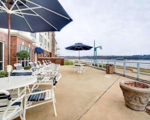 - une rangée de tables et de chaises avec parasols sur la terrasse dans l'établissement Clarion Suites Vidalia Riverfront, à Vidalia