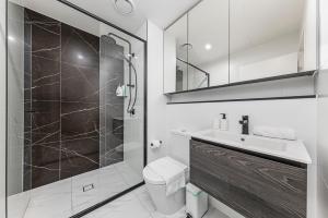 a bathroom with a shower and a toilet and a sink at Modern 2BR Free parking near Olympic park in Sydney +14 photos