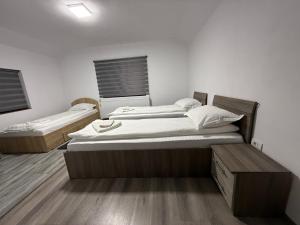 two beds sitting in a room with wooden floors at Casa Lupilor 2 Vidraru in Căpăţîneni-Ungureni
