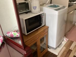 un forno a microonde appoggiato su un tavolo di legno accanto a un frigorifero di 森のハイジ ad Azumino Altre 4 foto