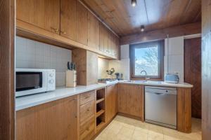 a kitchen with wooden cabinets and a microwave at Chalet Capriol by My Villa Collection in Cortina dʼAmpezzo +14 photos