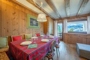a dining room with a table with a red table cloth at Chalet Capriol by My Villa Collection in Cortina dʼAmpezzo