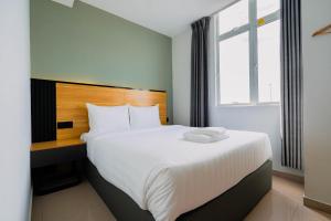 a bedroom with a large white bed with a window at Hotel M9 Sepang KLIA & KLIA 2 in Sepang