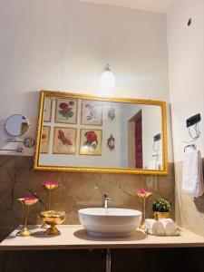 een badkamer met een wastafel en een spiegel bij Seclude Hampi 1800 in Jāmb