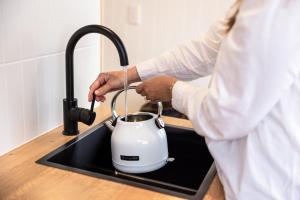 Een man giet vloeistof in een waterkoker. bij Seabrook Vineyard Retreat 