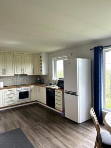 a kitchen with white cabinets and a white refrigerator at Suovka reindeer & bird lodge in Varangerbotn