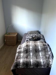 a bedroom with a bed with a blanket on it at Suovka reindeer & bird lodge in Varangerbotn