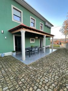 een groen huis met een patio ervoor bij Casa do Barbosa in Monção