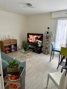 ein Wohnzimmer mit Sofa und Flachbildfernseher in der Unterkunft Escale Berckoise Studio Cosy Proche des Phoques in Berck-sur-Mer