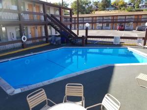 a large swimming pool in a hotel with chairs at Thunderbird Motel in Elko