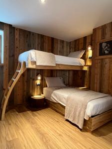 two bunk beds in a room with wooden walls at Al Truciolo in Andalo